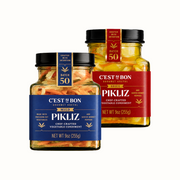 Two jars of Cést Si Bon Pikliz vegetable condiment on a white background