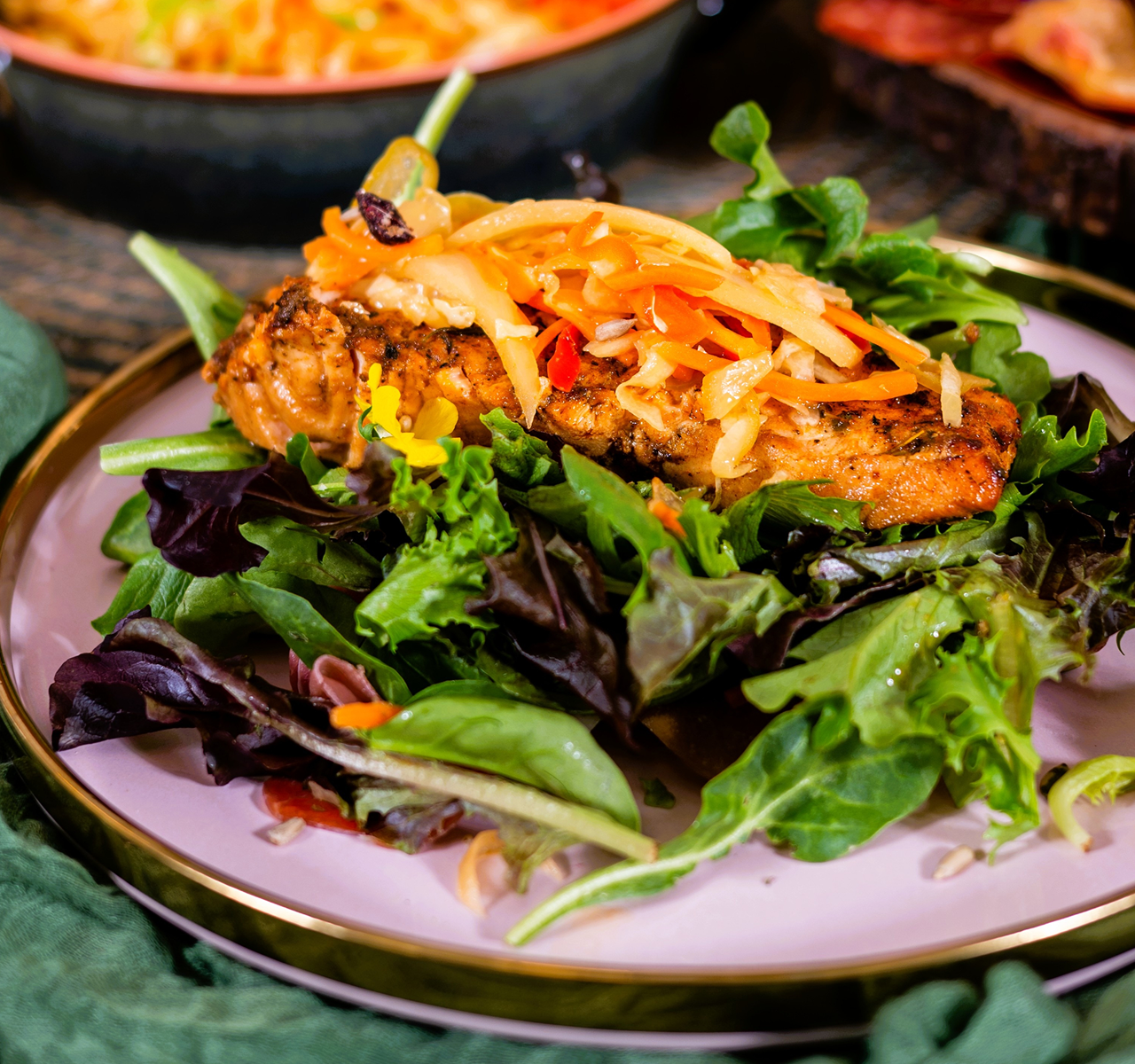 Salad with chicken and carrots on a pink plate
