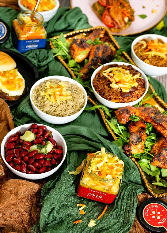 Assorted food items including bowls of beans, rice, and meat on a green cloth.