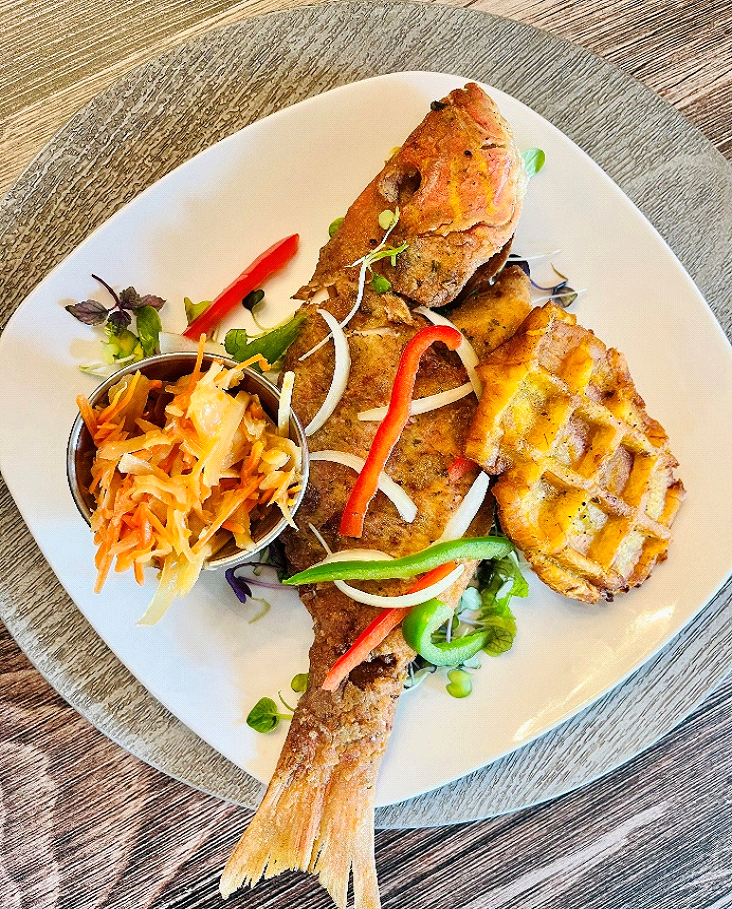 Plated fish dish with garnishes on a wooden table